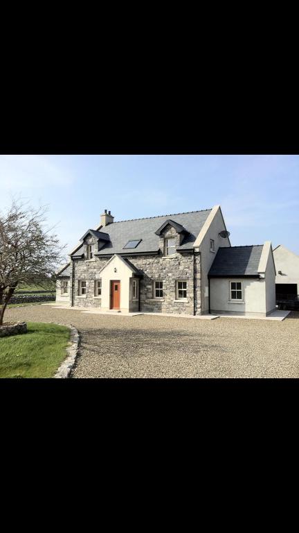 a large brick house with a driveway in front of it at Kilohill House in Ballyvaughan