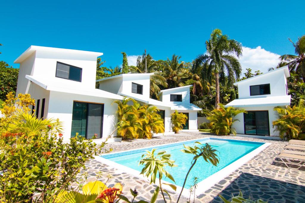 a villa with a swimming pool in front of a house at Residence Las Dos Palmas in Las Terrenas