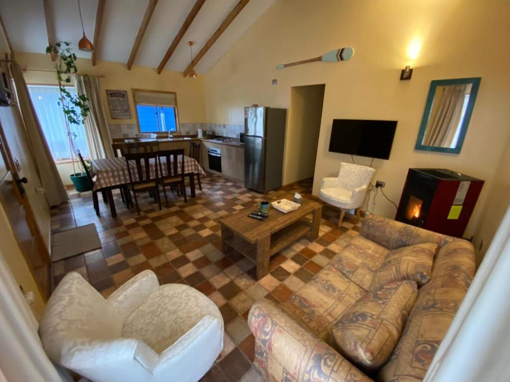 a living room with a couch and a kitchen at Cabañas Dahue in Valdivia