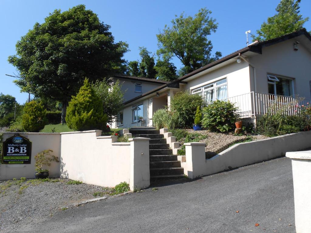 uma casa branca com escadas em frente em Mulberry Lodge B&B em Westport