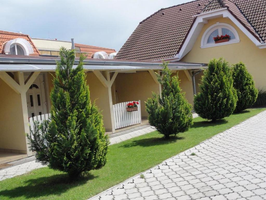 a row of trees in front of a house at Apartmány Úsmev in Veľký Meder