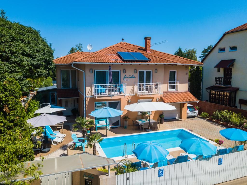 a house with a swimming pool and umbrellas at Villa Frida in Siófok