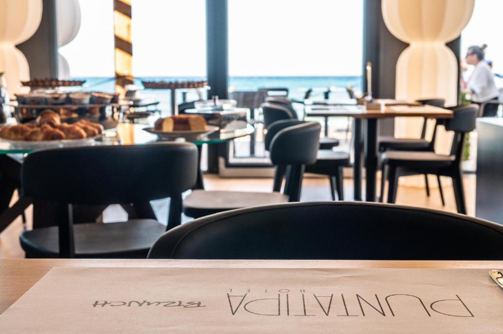 a restaurant with chairs and tables and a sign on a table at Hotel Punta Tipa in Trapani