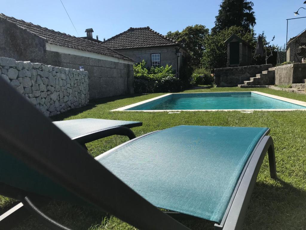 a pool with a table and a bench in the yard at Casa da Ponte in Baião