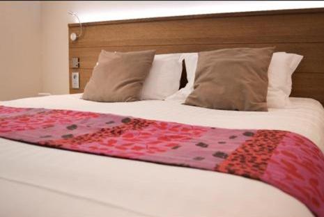En eller flere senge i et værelse på Hotel La Caleche