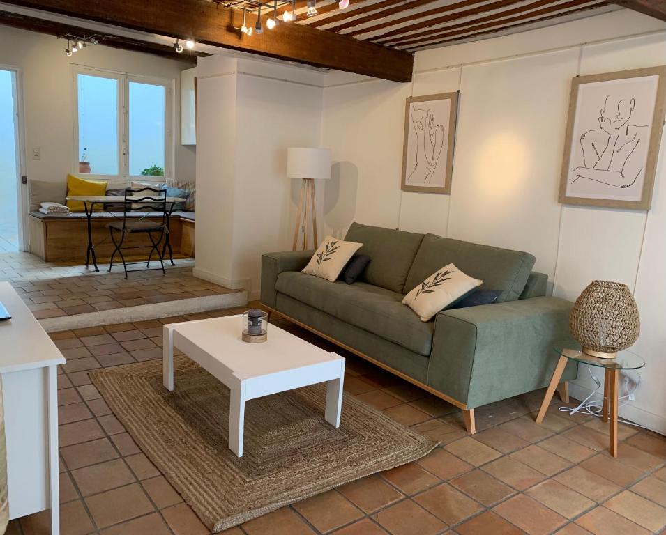 un salon avec un canapé vert et une table dans l'établissement Au 10, à LʼIsle-sur-la-Sorgue