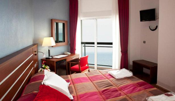 a hotel room with a bed and a desk and a window at La Familia Gallo Rojo in El Campello