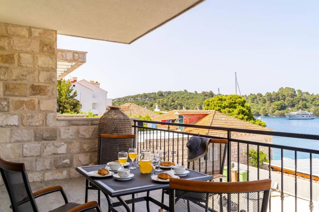 a table on a balcony with a view of the water at Corallium in Pomena