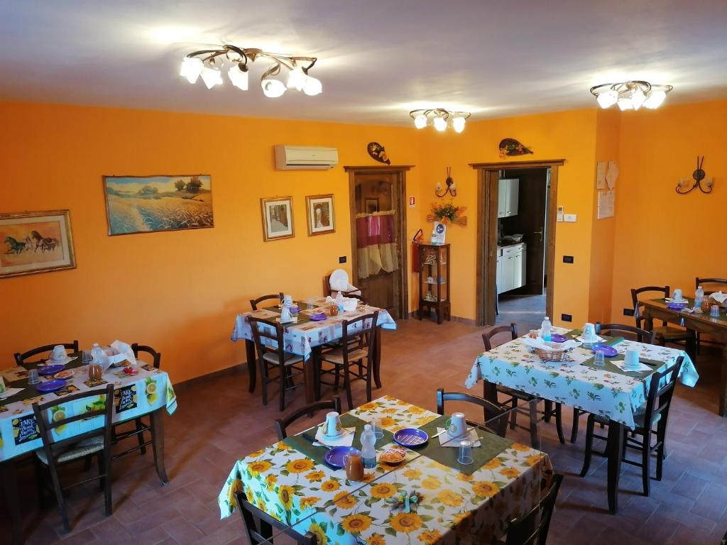 een eetkamer met tafels en stoelen en gele muren bij Piane Del Bagno in Saturnia