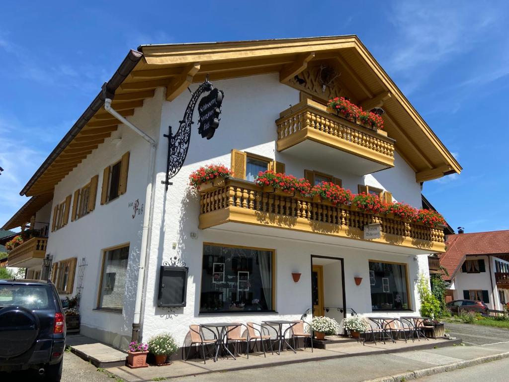 翁特拉梅尔高Gästehaus u Ferienwohnungen Veronika incl Frühstücksbuffet und KönigsCard mit 200 kostenlosen Attraktionen的带阳台和桌椅的白色建筑
