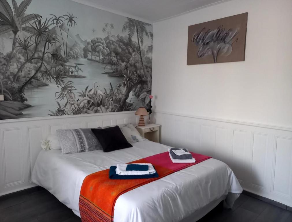 1 dormitorio con 1 cama con una pintura en la pared en Chez Chris, en Jard-sur-Mer
