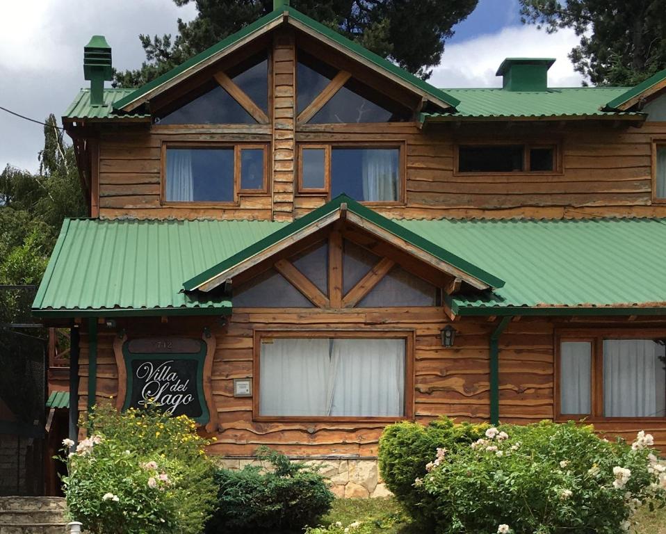 a wooden house with a green roof at Villa del Lago in San Carlos de Bariloche