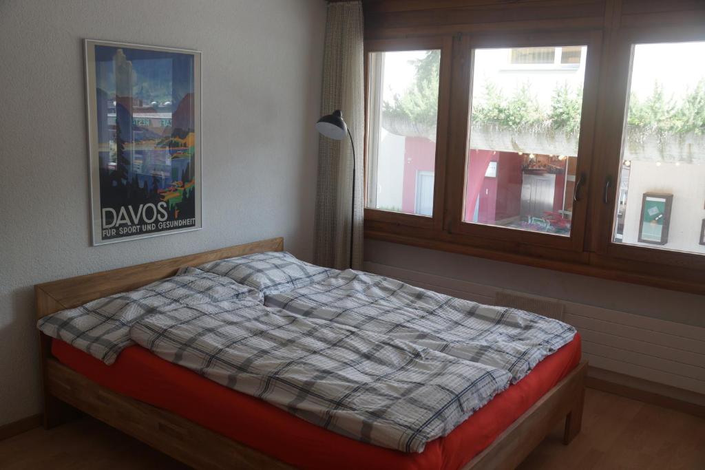 Bett in einem Zimmer mit Fenster in der Unterkunft Lovely 1-bedroom apartment in the heart of Davos in Davos