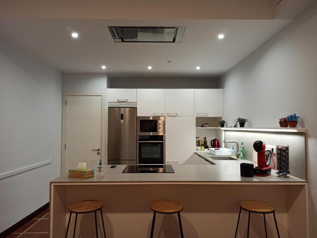 a kitchen with a counter and stools in it at Pagés in Sant Climent Sescebes