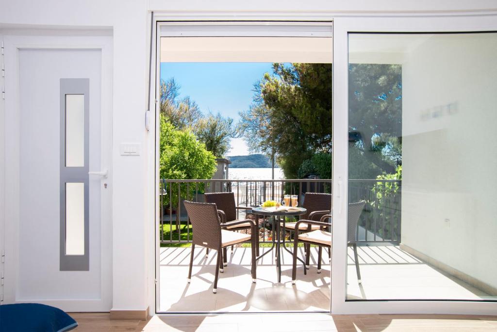 a glass door leading to a patio with a table and chairs at Holiday Home Ivana in Brodarica