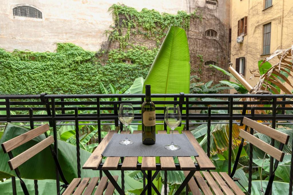 uma mesa com uma garrafa de vinho e dois copos em Leo's Colosseum - Private Apartments em Roma