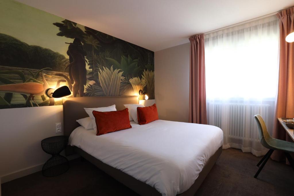 a bedroom with a large white bed with red pillows at Hôtel la Capelle Millau in Millau