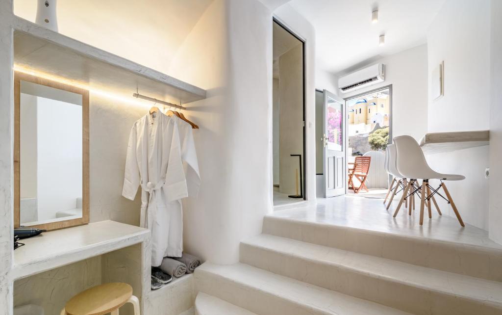 a white bathroom with stairs and a window at Anila Suites in Fira