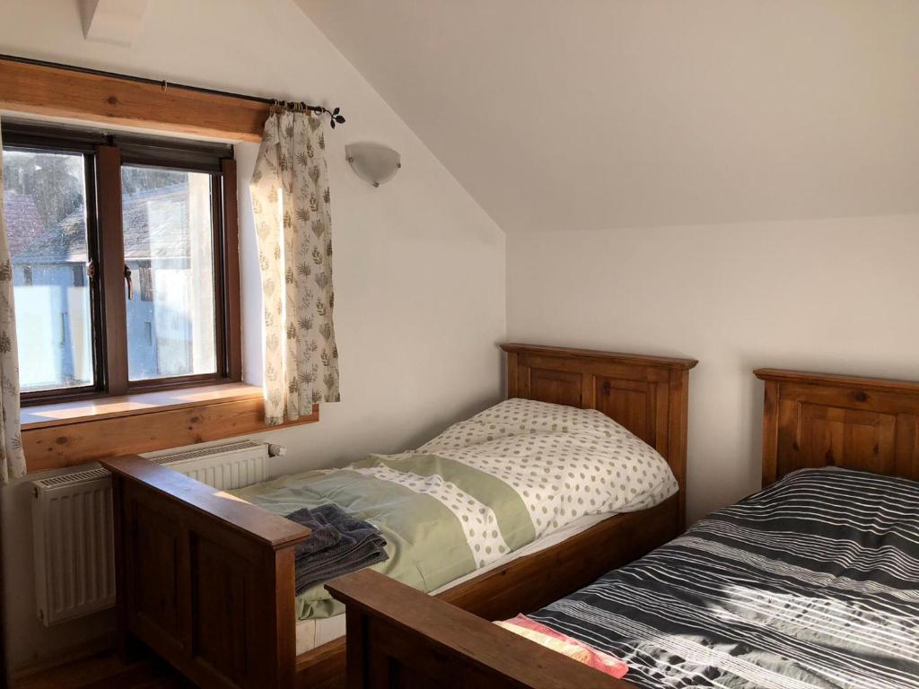 een slaapkamer met 2 aparte bedden en een raam bij Leśna Willa in Kowalewo