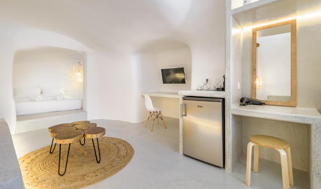 a kitchen with stools and a sink and a mirror at Anila Suites in Fira