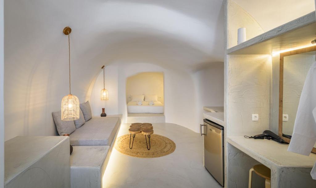 a white living room with a couch and a table at Anila Suites in Fira