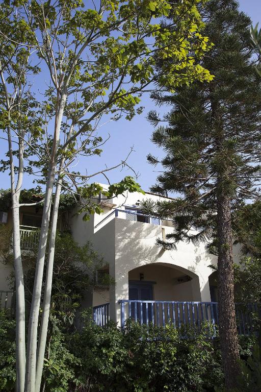 a white house with trees in front of it at Elpida Village in Istro