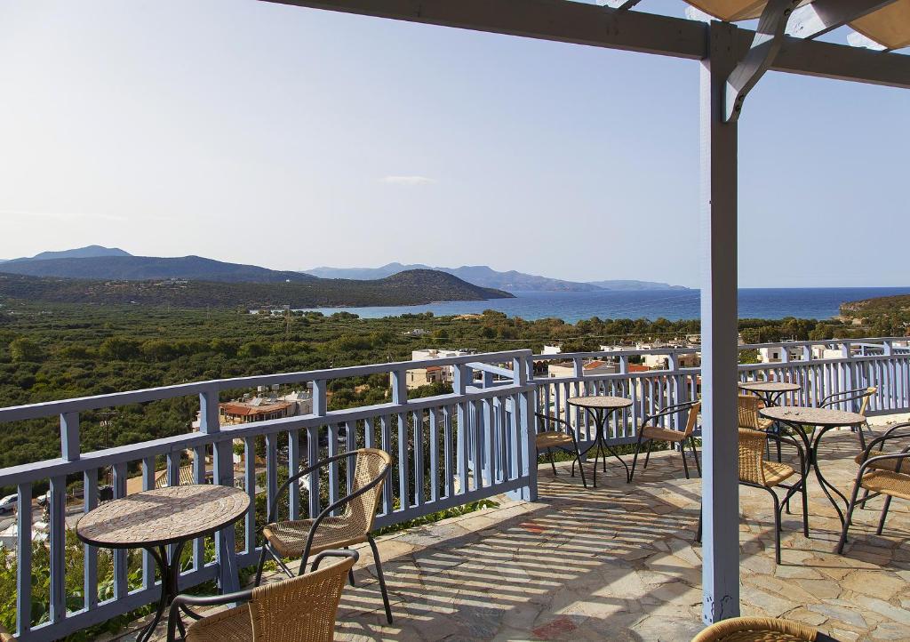 a balcony with tables and chairs and a view of the ocean at Elpida Village in Istro