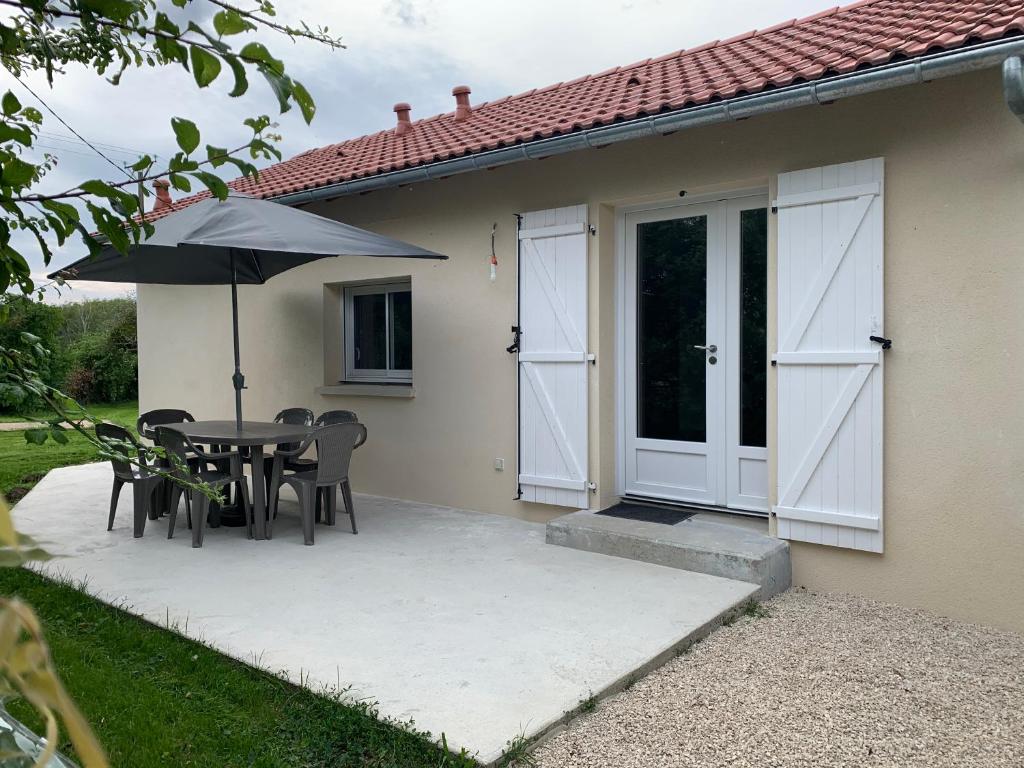 a patio with a table and chairs and an umbrella at loge de la Besnardière in Mareuil-sur-Cher