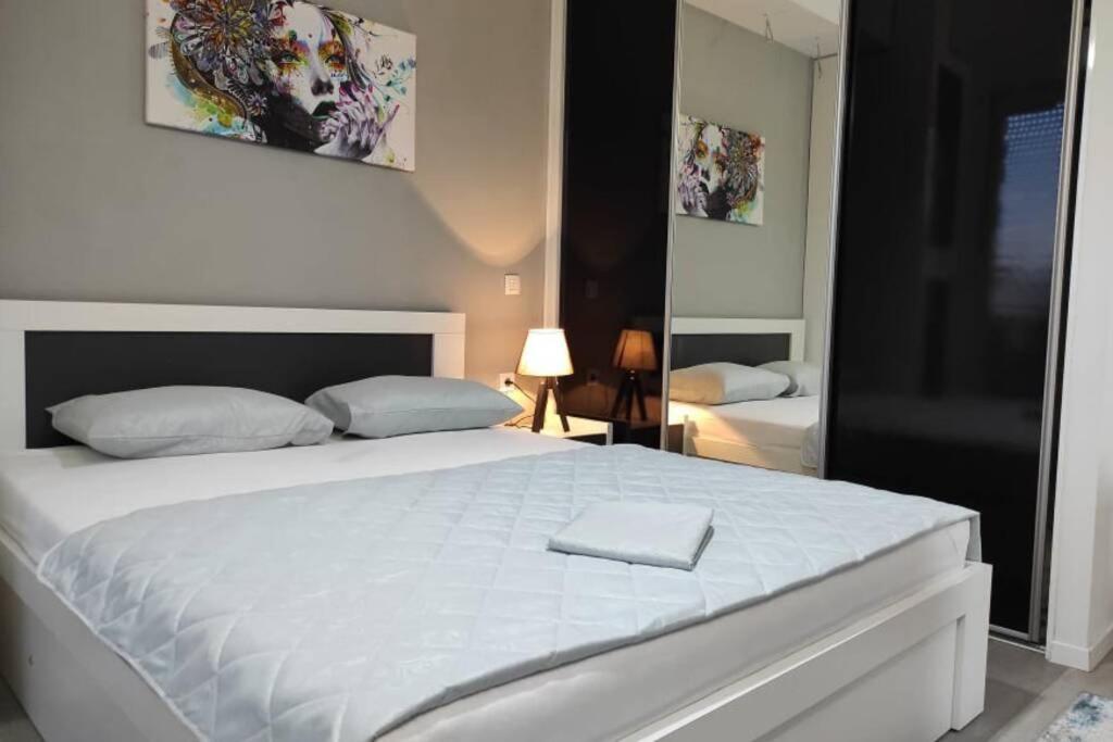 ein Schlafzimmer mit einem großen weißen Bett in einem Zimmer in der Unterkunft Centar One Apartmant in Skopje