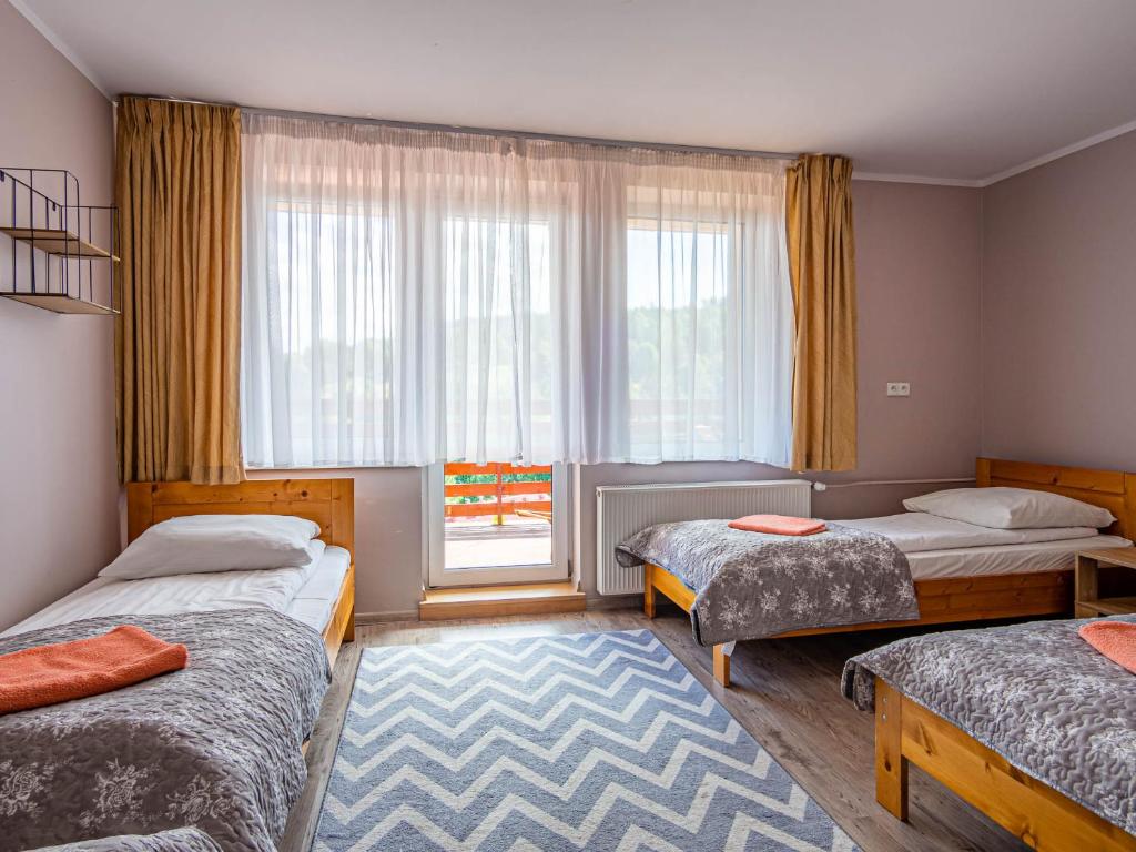 a bedroom with two beds and a window at Pensjonat Markus in Przesieka