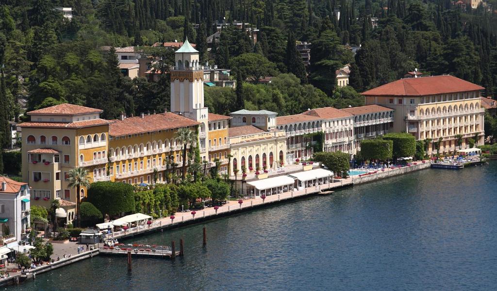 un grupo de edificios junto a una masa de agua en Grand Hotel Gardone, en Gardone Riviera