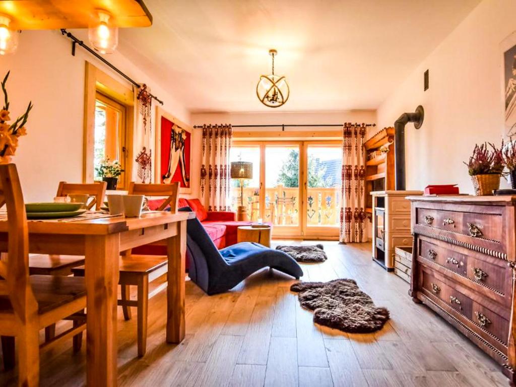 a living room with a table and a dining room at Villa Szymoszkowa SKI in Kościelisko