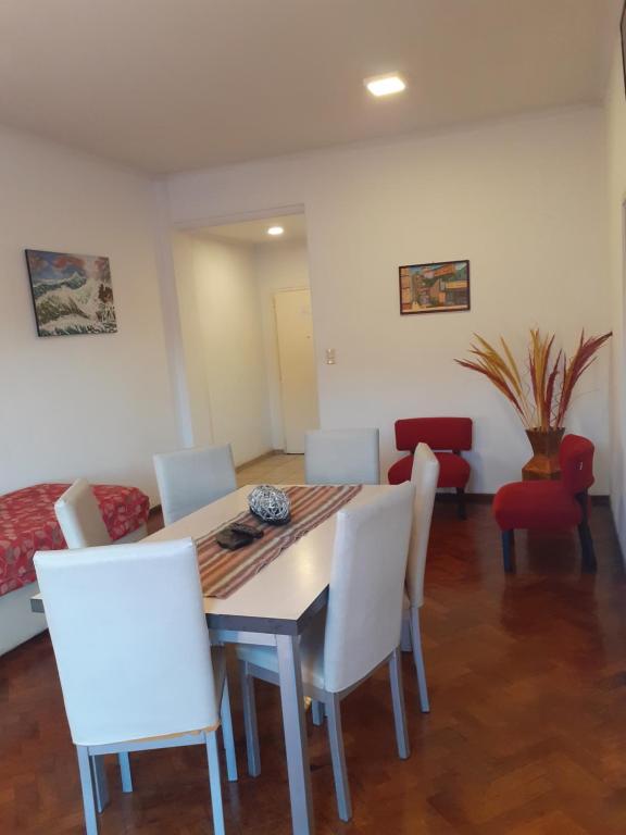 sala de estar con mesa y sillas blancas en Departamentos El Ceibo II en Mendoza