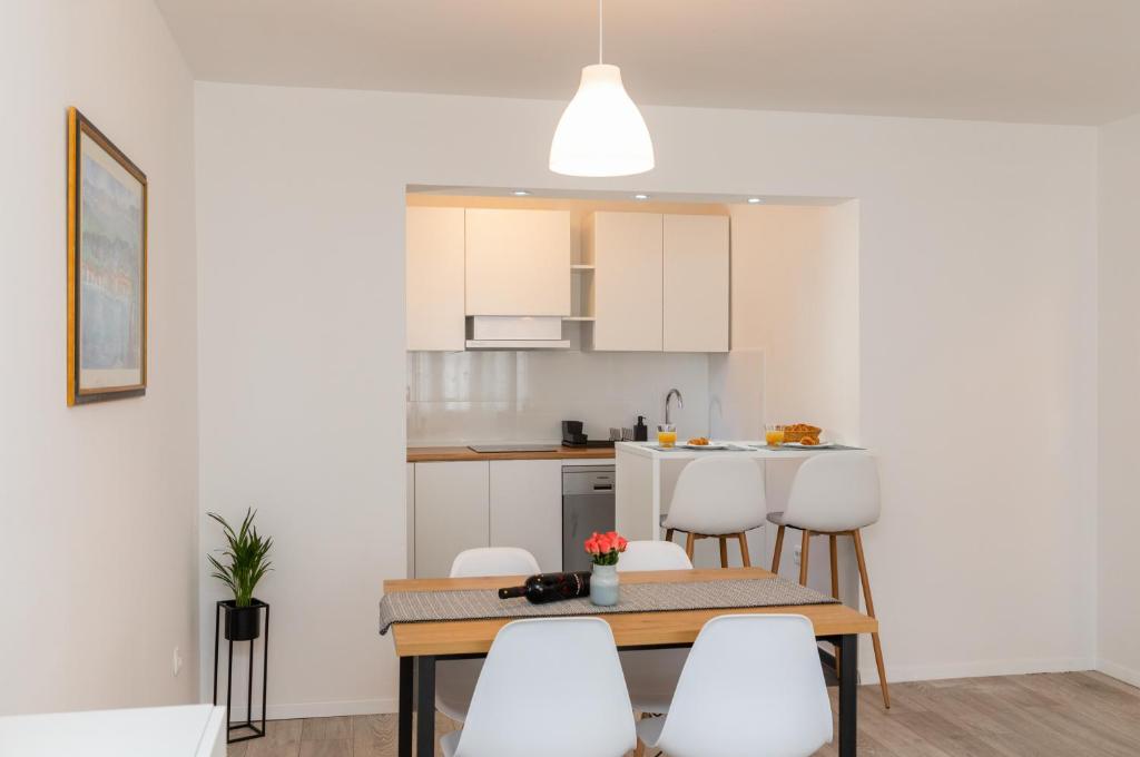 a kitchen and dining room with a table and chairs at Two Flowers Luxury Apartment in Supetar