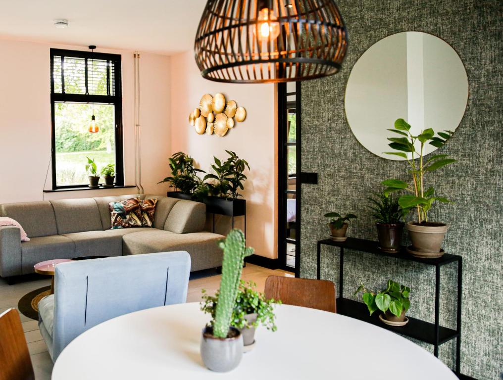 een woonkamer met een bank en een tafel met planten bij Vakantiehuisje De Barones in Middelburg