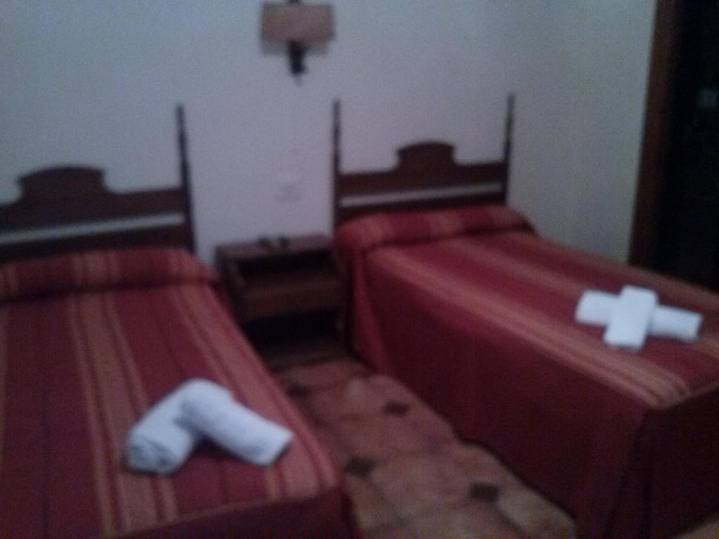 a room with two beds with crosses on them at Pension Rioja in Quinto