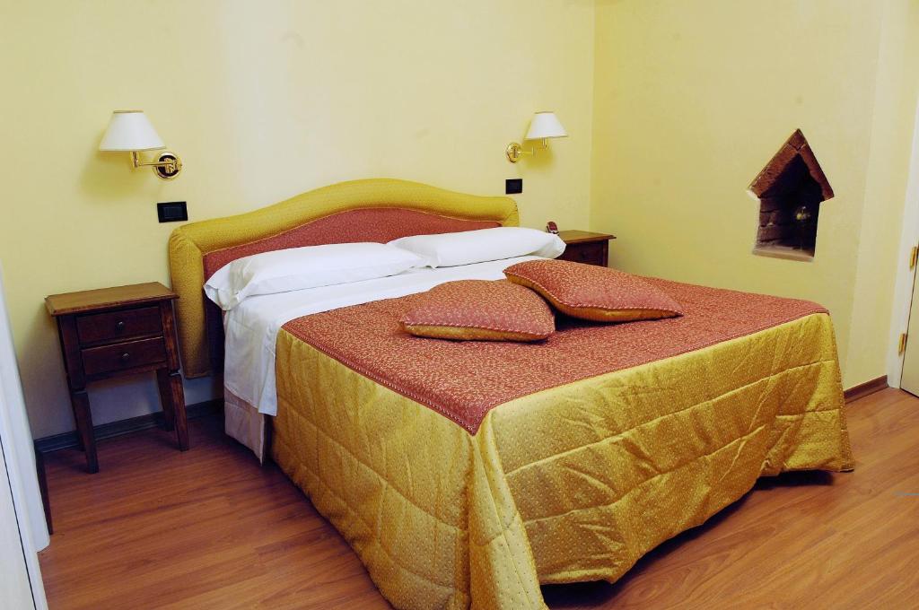 a bedroom with a bed with two pillows on it at Hotel Di Stefano in Pisa