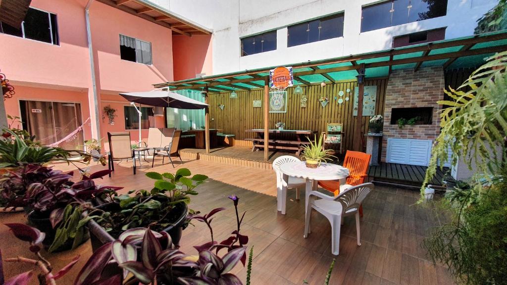 a patio with a table and chairs and plants at Residencial Recanto Paraíso BC - Apartamento in Balneário Camboriú