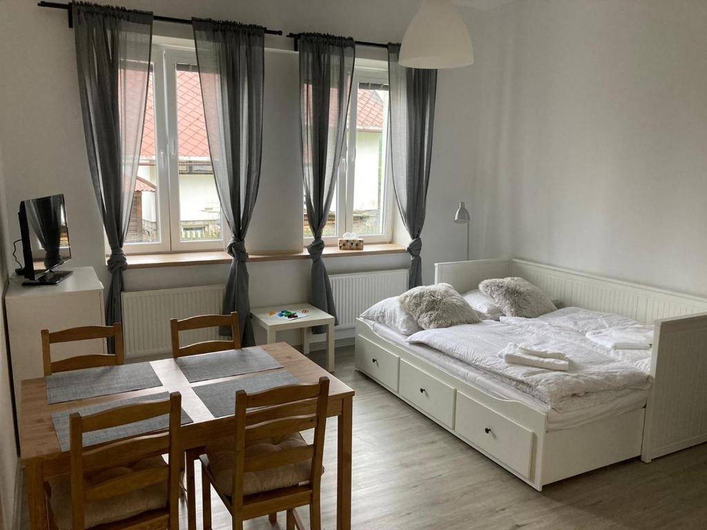 sypialnia z łóżkiem, stołem i krzesłami w obiekcie Apartmán Jasmína v Jeseníkách w mieście Karlovice