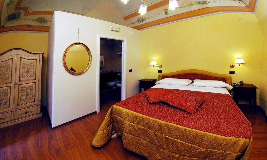 a bedroom with a large bed with a red blanket at Hotel Di Stefano in Pisa