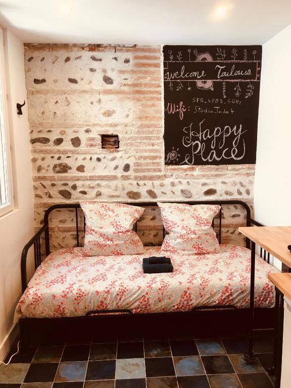 - une chambre dotée d'un lit avec un tableau noir sur le mur dans l'établissement Studio 1 personne Toulouse Centre Jeanne d'Arc, à Toulouse