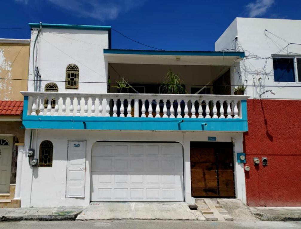 a white house with a balcony and a garage at Casa Cálido Hotel in Cozumel