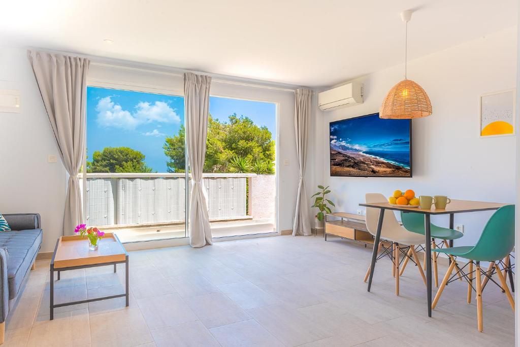 sala de estar con mesa y ventana grande en Bungalow Blue Dream 3 - Sea views, terrace and pool, en Gran Alacant