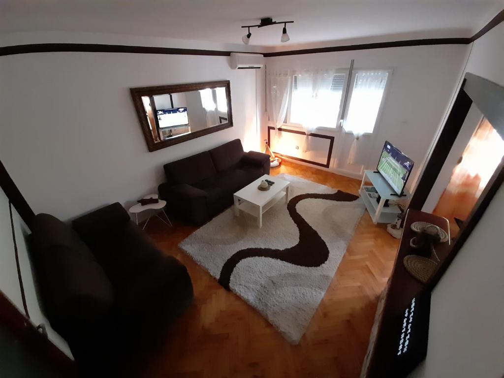 an overhead view of a living room with a couch and a television at moTIVATion apartment in Tivat