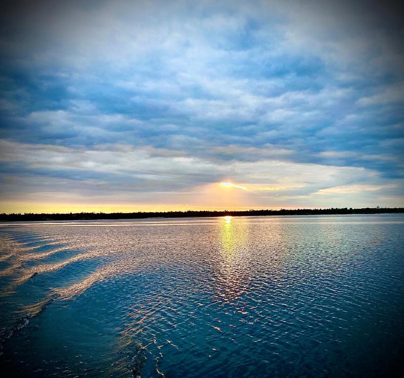 une grande masse d'eau avec le coucher du soleil au loin dans l'établissement NEU Familienfreundliche FeWo in Seennähe im Leipziger Süden, à Markkleeberg