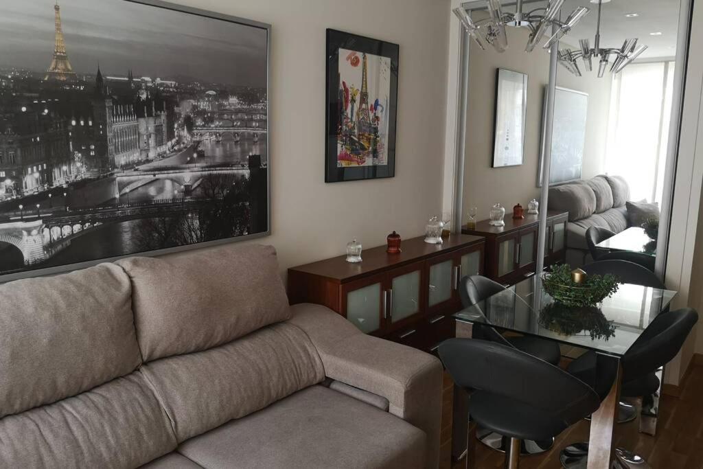 sala de estar con sofá y mesa de cristal en La casa del centro, en A Coruña