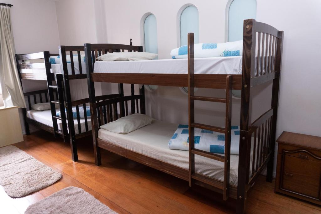 a room with three bunk beds in a room at Hostel e Pousada Tiradentes 774 in Passo Fundo