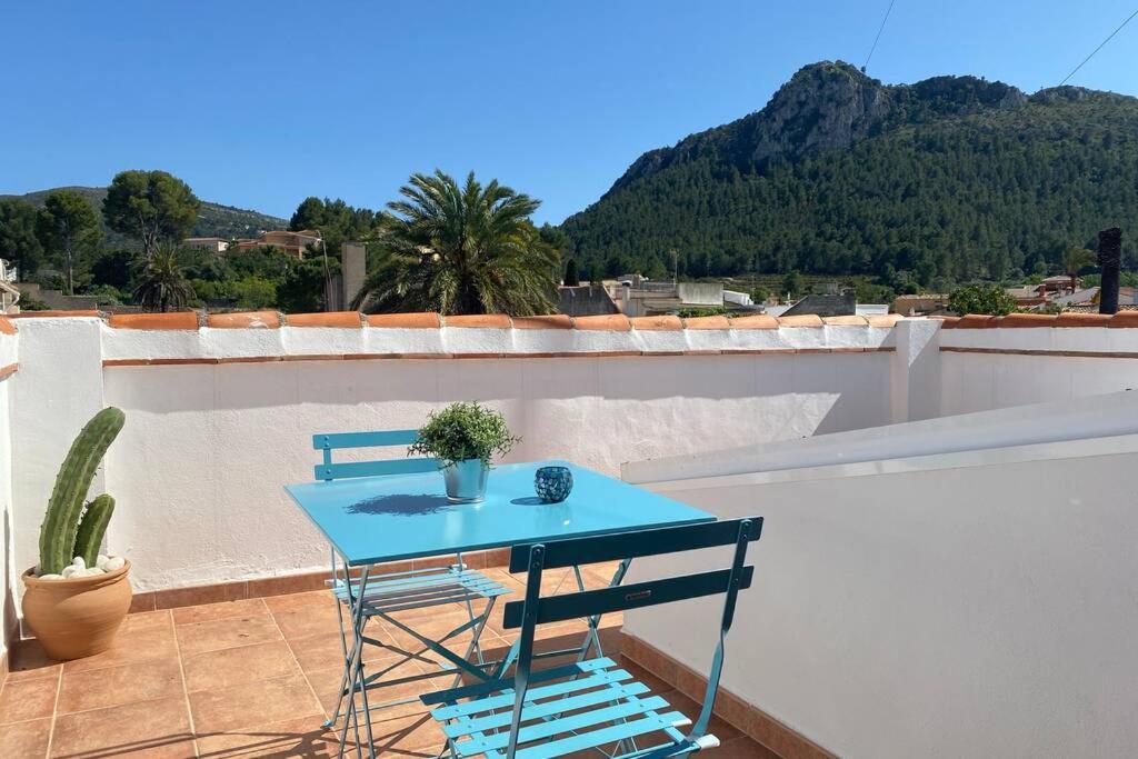 een blauwe tafel en stoelen op een balkon met een cactus bij Casa del Garcelan in Orba