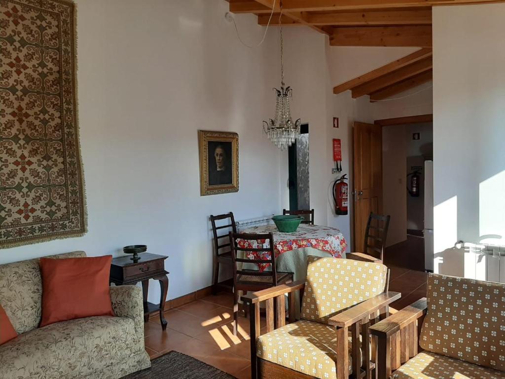 uma sala de estar com um sofá, cadeiras e uma mesa em Charming apt in historic building in Serra da Estrela national park em Vinhó