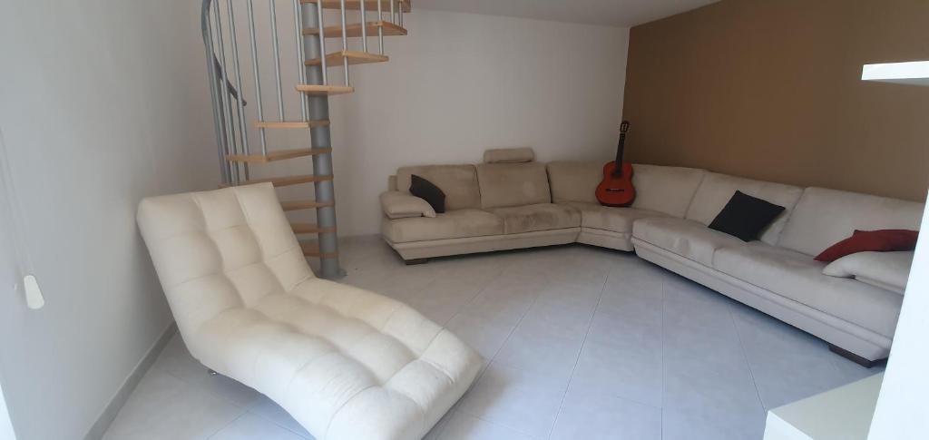 a living room with two white couches and a guitar at La casa nel barocco in Lecce